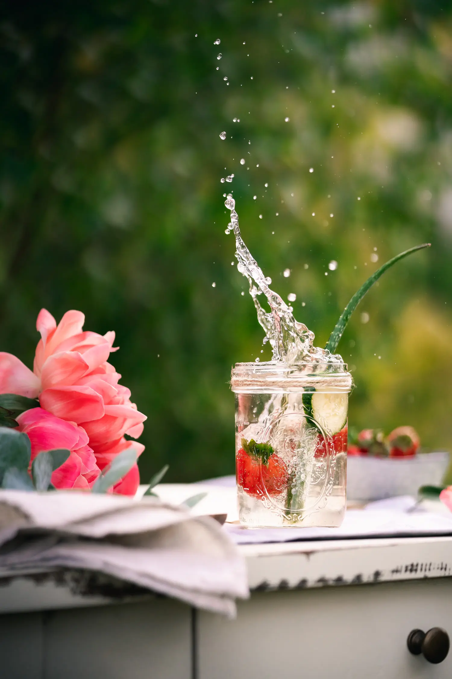 Wasser mit Geschmack :Erdbeere ins Glas gefallen mit Wasserspritzern