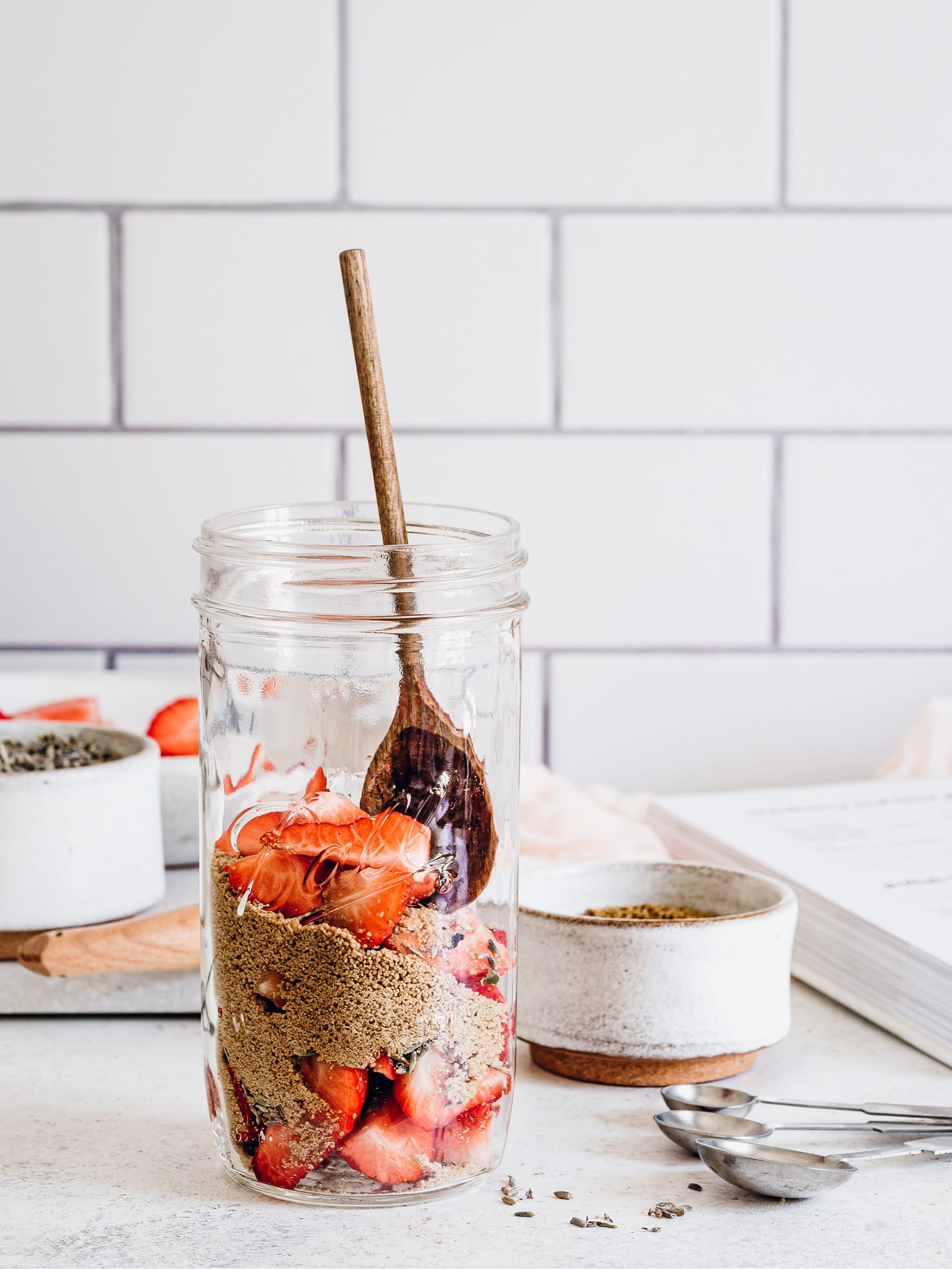 Brauner Zucker, Lavendelblüten und Erdbeeren im Glas